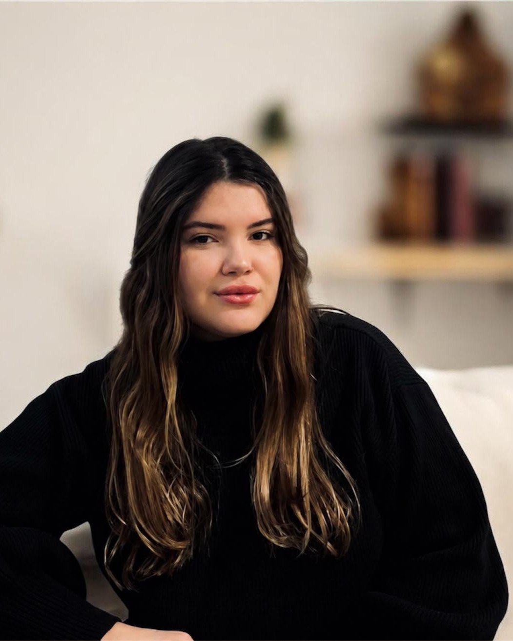 Bruna Guerreiro, psicóloga online, em ambiente acolhedor com estante de livros ao fundo